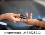 Action of human hands are giving and taking a car key. Buying the new car or car rental business concept scene, Close-up and selective focus at the object.