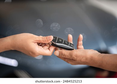 Action of human hands are giving and taking a car key. Buying the new car or car rental business concept scene, Close-up and selective focus at the object. - Powered by Shutterstock