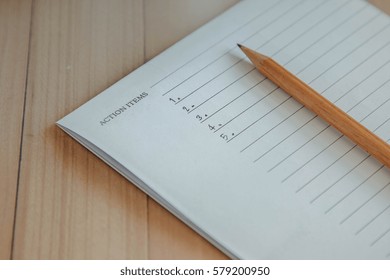 Action Items Write Down On Notebook By Pencil Put On Wooden Table