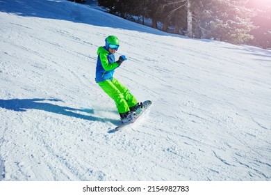 Action motion photo of a snowboarder boy on mountain ski slope with snow flying away from the snowboard