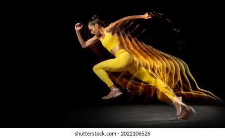 Action, Motion. Young Woman, Female Professional Track Athlete Running Isolated Over Black Studio Background In Mixed Neon Lights. Stroboscopic Effect.