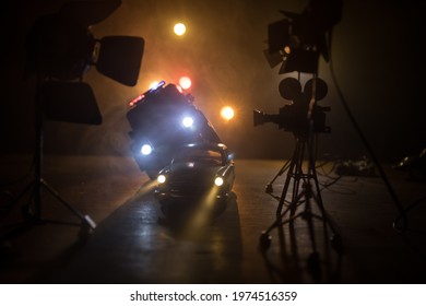 Action Movie Concept. Police Cars And Miniature Movie Set On Dark Toned Background With Fog. Police Car Chasing A Car At Night. Scene Of Crime Accident. Selective Focus