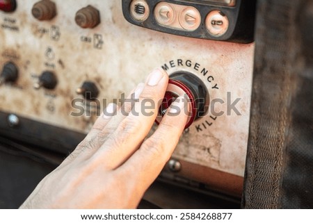 Action of an operator is activate on emergency shutdown button to suddenly stop the pumping machine. Industrial working scene, close-up.