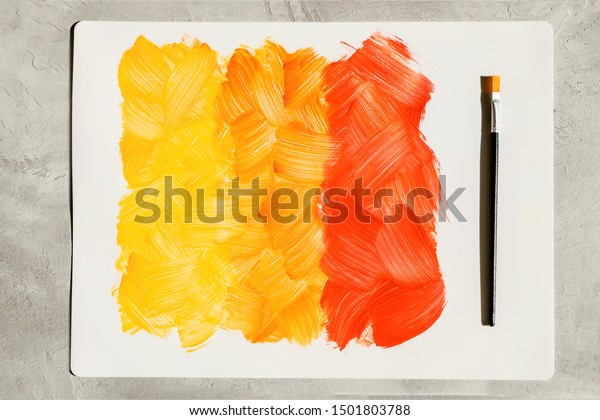 Action painting.\
Abstract Hand-painted yellow and orange art background.\
Multicolored paint strokes and\
brush.