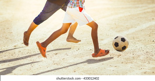 An Action Picture Of The Kids Are Playing Soccer Football In The Sunshine Day. Focus On The Legs And Ball.