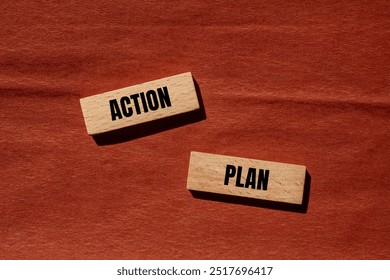 Action plan message written on wooden blocks with brown background. Conceptual action plan symbol. Copy space.