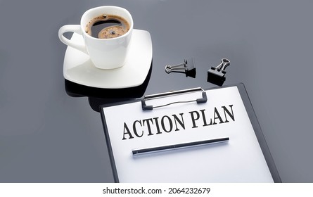 ACTION PLAN text on the paper sheet with coffee on the black background