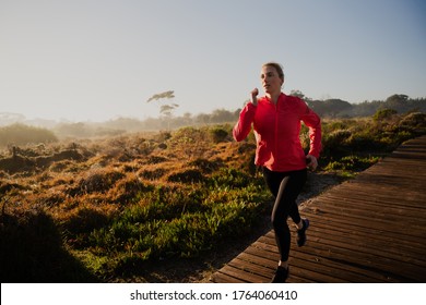 Action portrait of beautiful athletic female running in the park during sunrise - Powered by Shutterstock