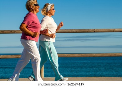 Action Portrait Of Elderly Women Jogging Together Outdoors.