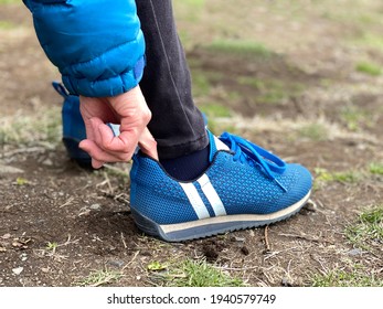 The Action Of Putting A Finger In The Heel Of Athletic Shoes