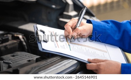 Action of a repairman is checking on multi-point checklist form during perform service the car parts. Industrial working scene, close-up and selective focus.