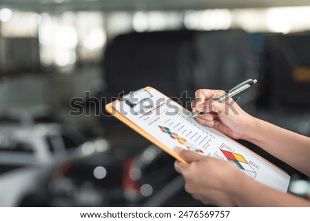 Action of a safety supervisor hand is checking on checklist of chemical and hazardous material form to verify the risk with blurred background of factory storage workplace. Industrial working scene.