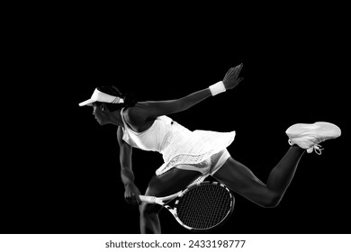 Action shot of female tennis player performing backhand stroke against black studio background. Monochrome filter. Concept of women in sport, active lifestyles, tournaments, energy, movement. - Powered by Shutterstock