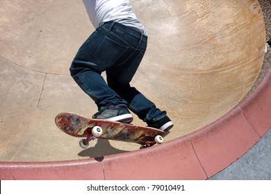 Action shot of a young skateboarder skating sideways against the wall of the bowl at a skate park. - Powered by Shutterstock