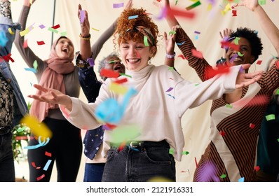 Action shot of young white woman celebrating International Women's Day with friends and ticker tape - Shutterstock ID 2121916331