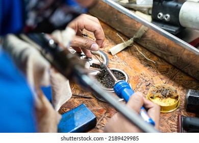 Action Of A Technician Is Soldering And Repairing The Electronic Part On The Workbench. Industrial Working Action Photo, Close-up And Selective Focus.