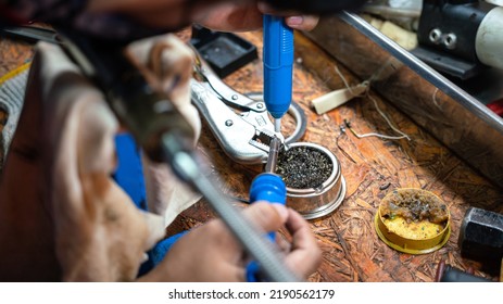 Action Of A Technician Is Soldering And Repairing The Electronic Part On The Workbench. Industrial Working Action Photo, Close-up And Selective Focus.