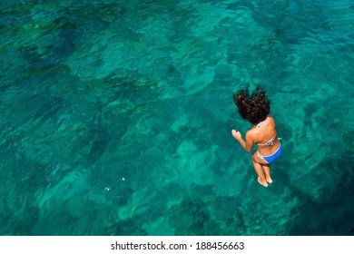 An action of a woman jumping to the crystal sea, Krabi, Thailand