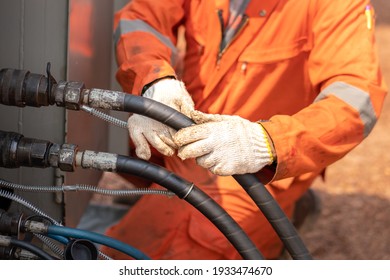 Action of worker hand is connecting and checking to high-pressure hydraulic hose line of power pack engine. Industrial working action photo, Close-up and selective focus. 