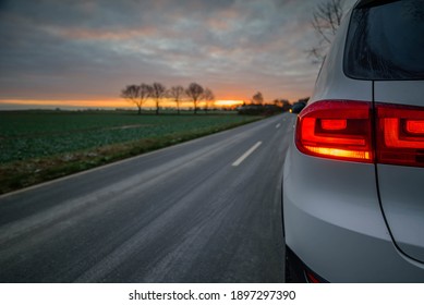 Activated warning lamps on the white car at the emty road in the countryside. - Shutterstock ID 1897297390