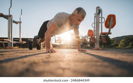 Active amputee athlete doing push-ups in the open outdoor gym - Powered by Shutterstock