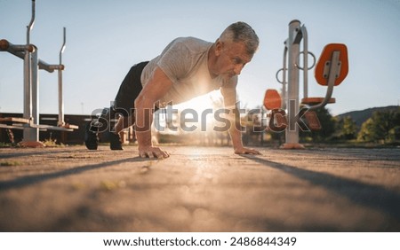 Active amputee athlete doing push-ups in the open outdoor gym