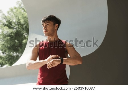 Active Asian man using app on smart watch for select music, Measure your heartbeat, and calories burned. Fitness, energy and athlete runner doing outdoor cardio workout for good health.