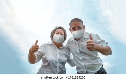 Active Asian Old Man And Old Woman Confident Protect Coronavirus With Face Mask In Pandemic Prevention. Grandfather And Grand Mother Show Tump Up With Good Health To Wearing Medical Ma