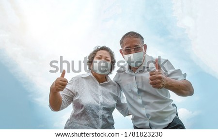active asian old man and old woman confident protect coronavirus with face mask in pandemic prevention. grandfather and grand mother show tump up with good health to wearing medical ma