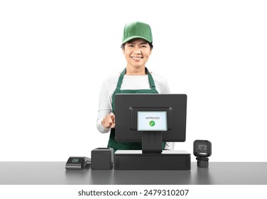 Active asian seller wear green apron and green cap smiling with point of sale terminal or cashier desk isolated