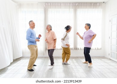 Active Asian Senior Group Mix With Man And Woman Exercise By Dancing Together At Home With Relaxing, Smiling And Laughing. Indoor Activity For Mature Seniors And Retirement People. Focus On Senior Man