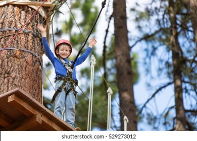 Active Brave Little Boy Enjoying Climbing At Treetop Adventure Park