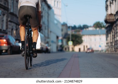 Active Caucasian Man In Sport Clothes And Sneakers Cycling On City Street. Close Up Of Muscular Male Legs Riding Bike Outdoors. Active Lifestyles.