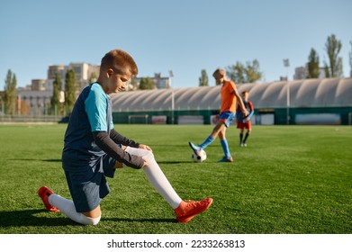 Active children playing football on green sport field outdoor - Powered by Shutterstock