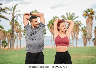 Active couple engaging in a refreshing and energizing stretching routine to enhance flexibility and promote overall fitness on the shoreline while enjoying each other company and motivation. High - Powered by Shutterstock - Get 15% off with code: PIKWIZARD15