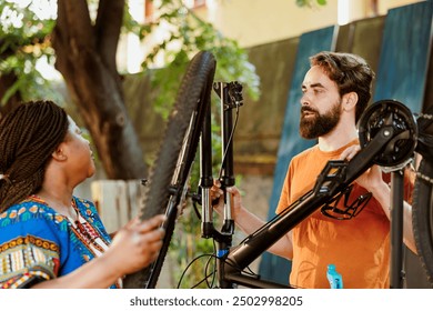 Active couple inspecting and repairing broken bicycle tire for summer leisure sport activity. Healthy energetic man and woman outdoors doing bike gear maintenance with work tools. - Powered by Shutterstock