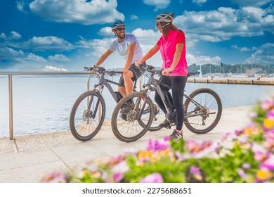 Active couple riding an E-Bike during vacations in the south
