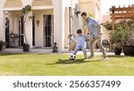 Active dad and sporty son boy playing soccer on backyard, having fun, enjoying sports football game, outdoor family leisure, fatherhood, childhood, kicking ball on grass on house backyard. Banner shot