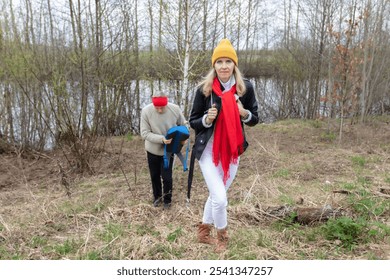 Active elderly Caucasian couple hiking with backpacks and hiking poles enjoying their adventure. - Powered by Shutterstock