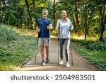 An active elderly couple engaging in a healthy walk on a forest path, using Nordic walking poles, promoting fitness and outdoor activity