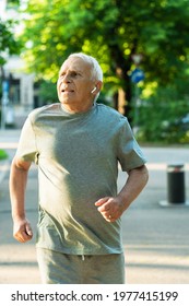 Active elderly man during his jogging workout in a city park