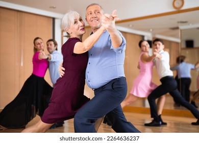 active elderly people attend dance lessons for amateurs and learn to dance tango in their free time - Powered by Shutterstock