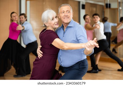 active elderly people attend dance lessons for amateurs and learn to dance tango in their free time - Powered by Shutterstock