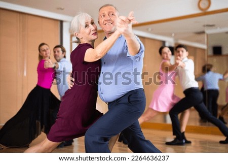 active elderly people attend dance lessons for amateurs and learn to dance tango in their free time