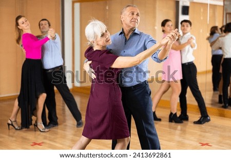 active elderly people attend dance lessons for amateurs and learn to dance waltz in their free time