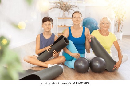 Active family of grandmother, mother and grandson posing in gym with fitness equipment. Active lifestyle, hobby, sport - Powered by Shutterstock