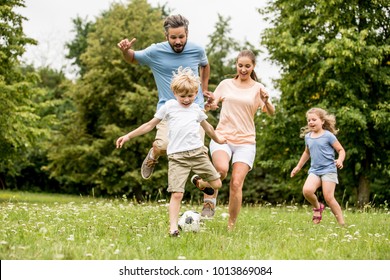 Active family play soccer in their leisure time - Shutterstock ID 1013869084