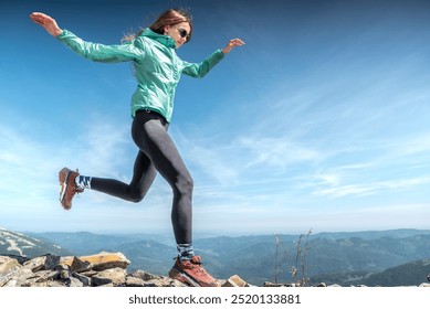 Active female athlete with legs apart jumping against clear blue sky on sunny day - Powered by Shutterstock