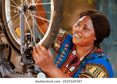 Active female cyclist checking tire as yearly bike rubber maintenance routine. Detailed image of enthusiastic sporty african american woman gripping and examining damaged bicycle wheel for dismantle. - Powered by Shutterstock