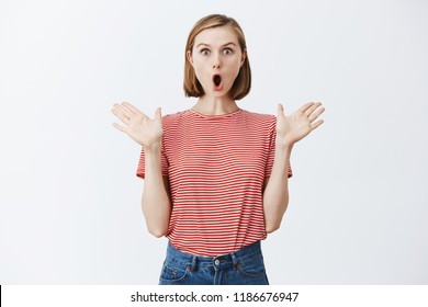 Active female volunteer always has suggestions and ideas, stunned and thrilled, standing with spread palms and opened mouth with excitement and thrill, explaining amazing details of story emotionally - Shutterstock ID 1186676947